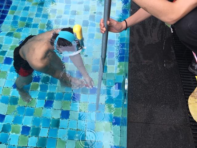 ช่างไฟกำลังเปลี่ยนหลอดไฟใต้น้ำในสระว่ายน้ำวิลล่าที่เกาะสมุย